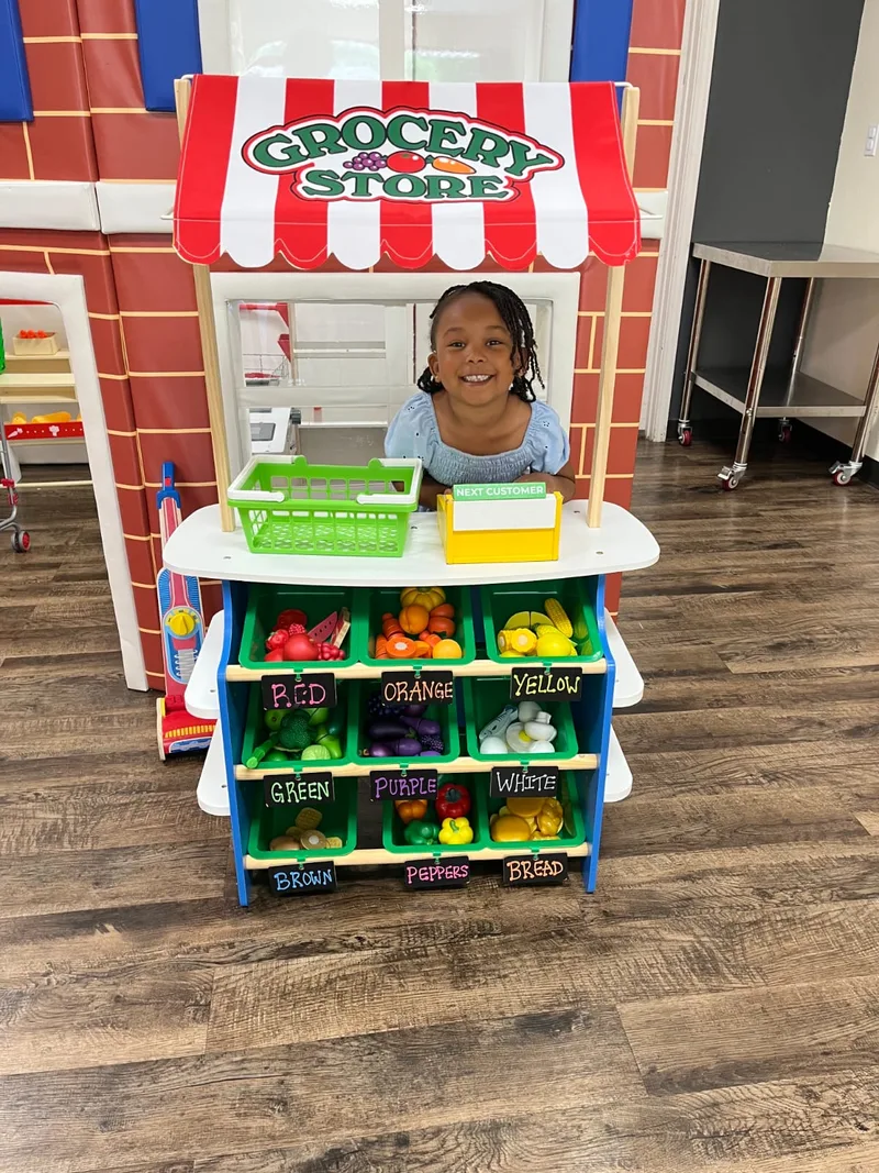 Child playing at a pretend grocery stand